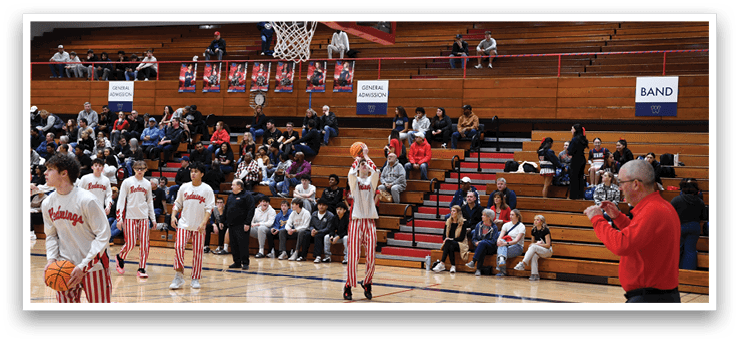 A group of people are playing basketball on a court, with a man holding a camera and recording the game. AI generated content