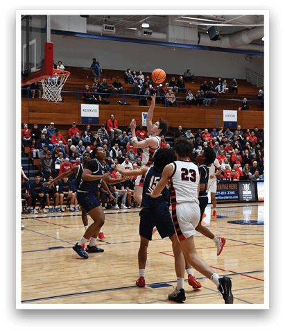 A basketball game is taking place with a player in the air attempting to shoot the ball. The crowd is watching intently as the player jumps up to make the shot. AI generated content