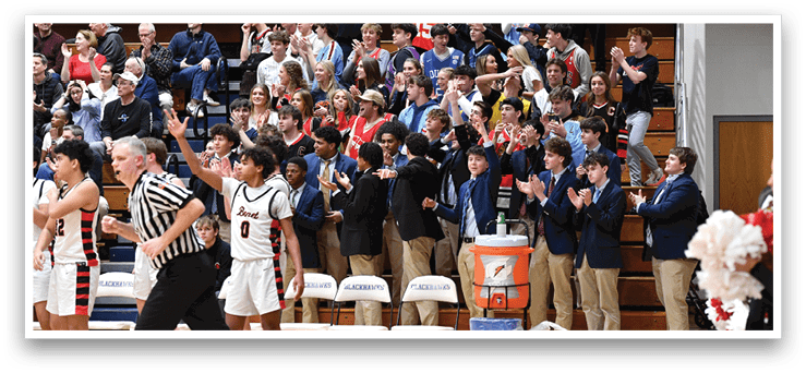 A group of people are standing on a basketball court, with some of them holding up their hands. The crowd is watching the game, and there are several chairs placed around the court. A referee is present, and a bottle can be seen on the court. AI generated content
