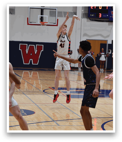 A basketball game is in progress with players on the court. One player is holding a basketball, and another player is attempting to block his shot. The players are wearing uniforms and are actively engaged in the game. AI generated content