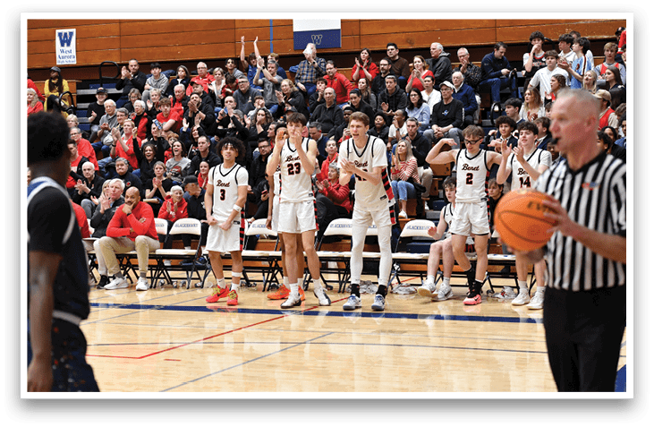 A group of people are playing basketball in a gym. The crowd is watching the game, and the players are holding their hands up in the air. The referee is standing on the sideline, and there are several chairs placed around the court. AI generated content