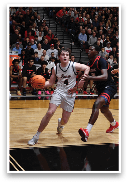 A basketball game is taking place with a crowd of people watching. A man is holding a basketball and is about to pass it to another player. AI generated content