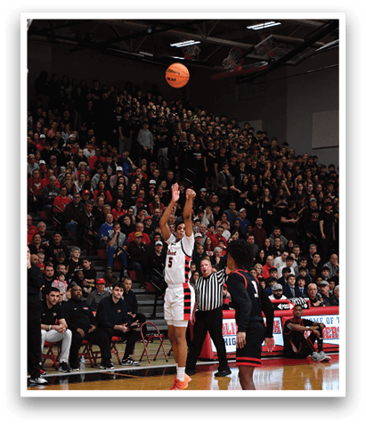 A basketball player is in the air, attempting to dunk the ball. The crowd is watching intently as the player jumps. AI generated content