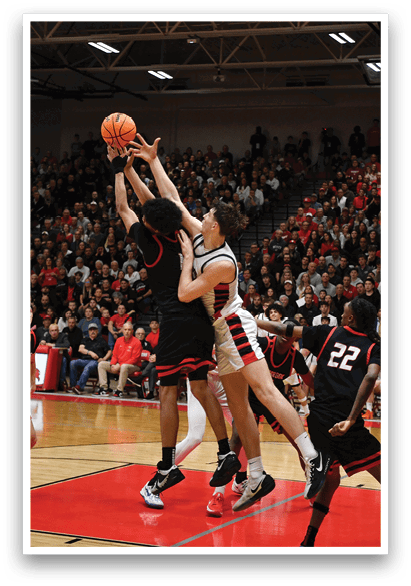 Two basketball players are fighting for the ball, with one player attempting to shoot the ball while the other tries to block him. The crowd is watching the intense play unfold. AI generated content