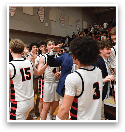 A group of young men in uniforms are hugging each other on a basketball court. AI generated content
