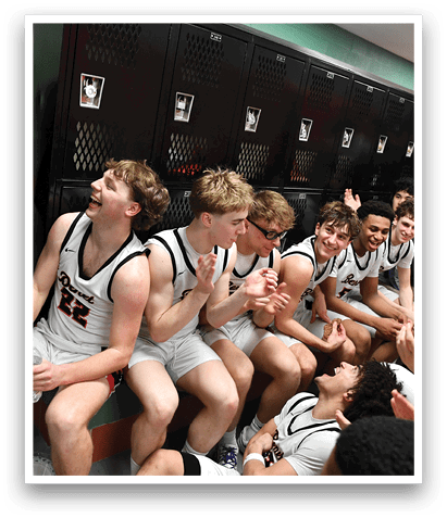 A group of young men are sitting on the floor in a locker room, wearing sports uniforms. They are laughing and enjoying each other's company. AI generated content
