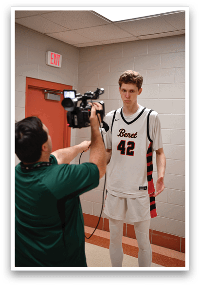 A man wearing a basketball uniform is being interviewed by a reporter. AI generated content