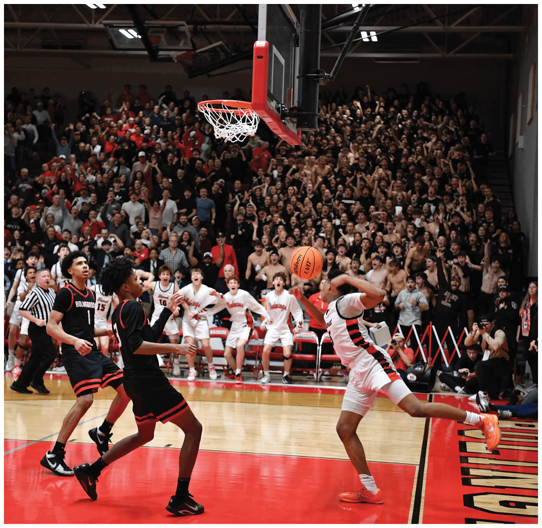 A basketball player leaps into the air to block a shot, while a crowd of fans watches intently. AI generated content