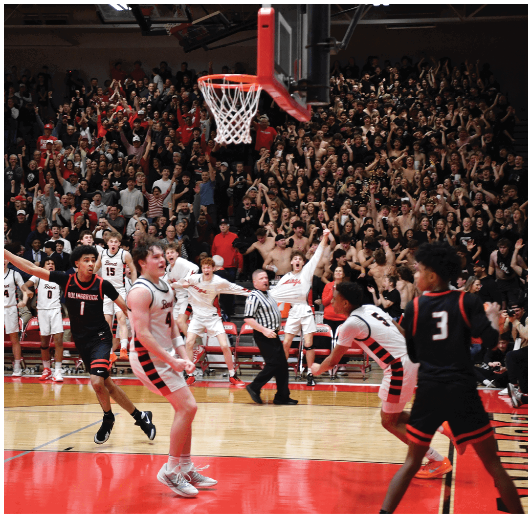 A basketball game is taking place with a crowd of people watching. The players are actively engaged in the game, with one player attempting to shoot a basket. The crowd is enthusiastic, and the atmosphere is lively. AI generated content