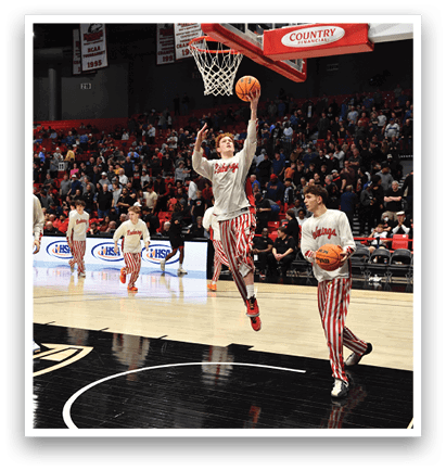Two men in striped pants are playing basketball, one of them is attempting to dunk the ball through the hoop. AI generated content