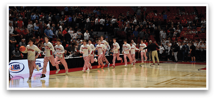 A group of young men wearing red and white striped pants are walking on a basketball court. AI generated content