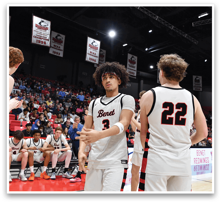 A group of basketball players are on the court, with one player holding his hand up. The players are wearing uniforms and are surrounded by a crowd of spectators. AI generated content