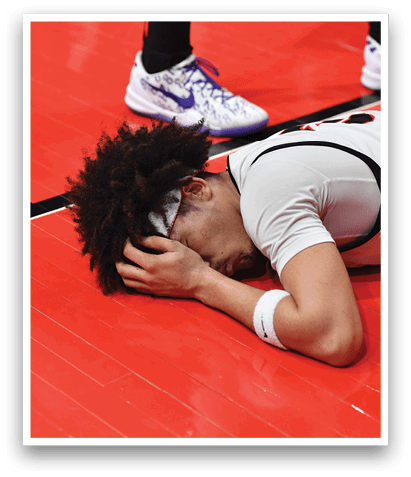 A basketball player is lying on the court with his head in his hands. AI generated content