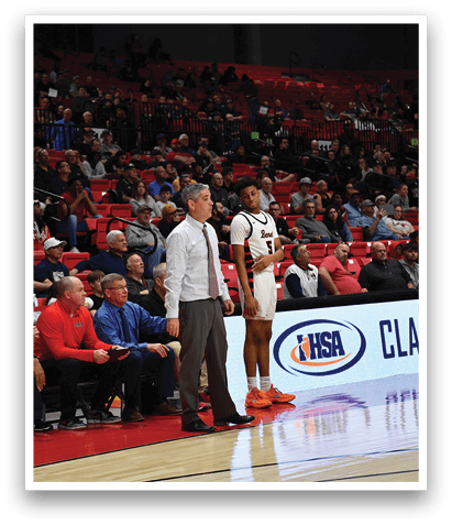 A basketball game is in progress with a crowd of people watching. A man is standing on the court holding a whistle, and another man is sitting on the bench. The audience is composed of various individuals, some sitting and others standing. The scene is lively and filled with anticipation as the game unfolds. AI generated content