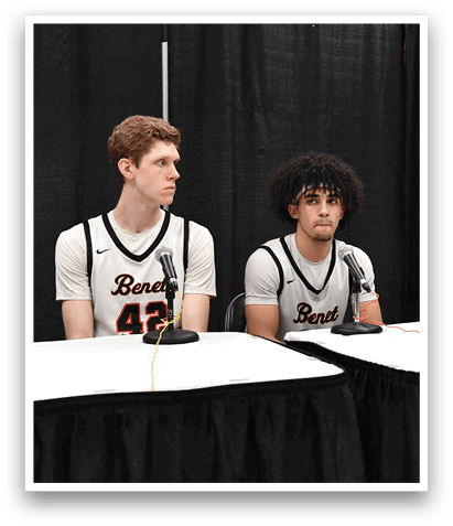 Two men wearing basketball jerseys are sitting at a table with a man in a suit. AI generated content