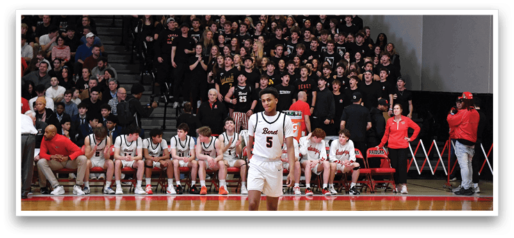A basketball game is taking place with a crowd of people watching. The players are on the court, and one player is holding a basketball. The spectators are seated in the stands, watching the game intently. AI generated content