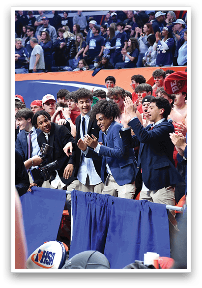 A group of people are standing in front of a crowd, some of them wearing suits. The crowd is watching and clapping, creating a lively atmosphere. AI generated content