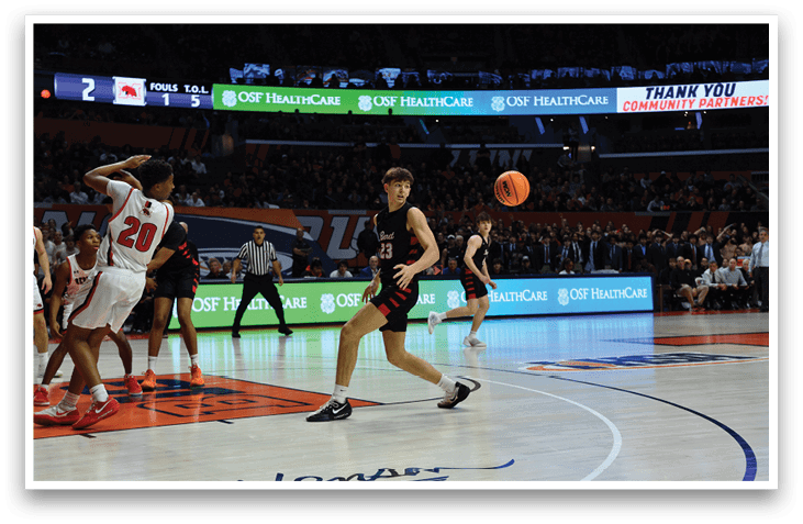 A basketball game is in progress with a player in a red jersey running towards the ball. AI generated content
