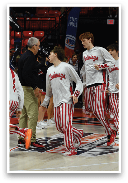 A group of basketball players wearing red and white striped uniforms are walking on the court. AI generated content