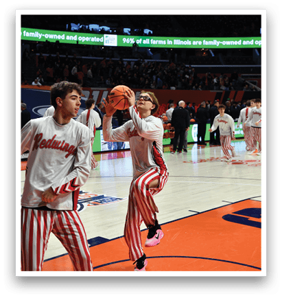 Two men in striped pants are playing basketball. One man is holding a basketball and the other is reaching for it. AI generated content