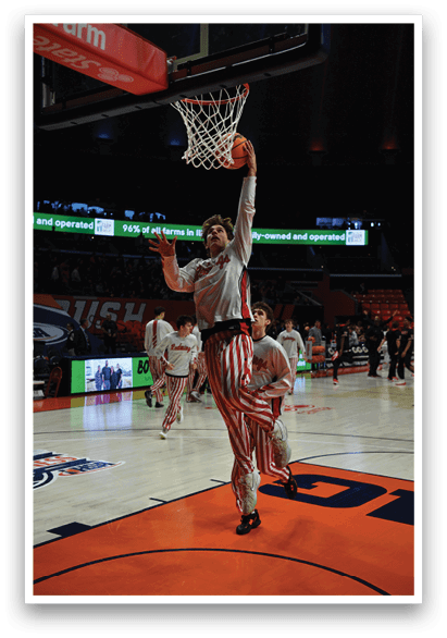 A basketball player is dunking a basketball through a hoop while other players look on. AI generated content