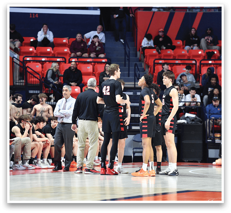 A group of people are standing on a basketball court, engaged in a conversation. There are several chairs placed around the court, and a bench is visible in the background. A sports ball is located near the center of the court. AI generated content