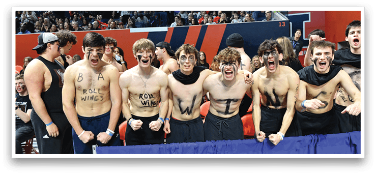 A group of young men are standing on a court, wearing black and white shirts and holding their arms up. They are all wearing face paint, and some of them have their shirts off. The crowd is watching them, and there are several chairs in the background. AI generated content