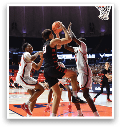 Basketball players on a court, one player is trying to block the shot of another player. AI generated content
