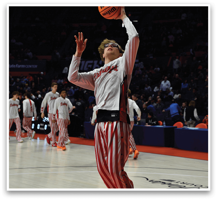 A basketball player in a white shirt and red striped pants is jumping to hit a basketball. AI generated content