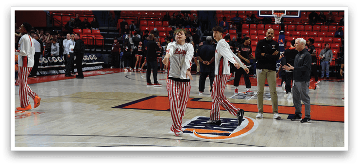 A group of men in red and white striped pants are standing on a basketball court. AI generated content