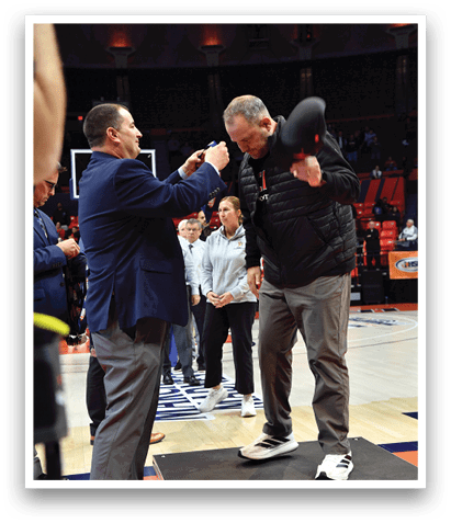A man in a suit shakes hands with another man on a basketball court. AI generated content