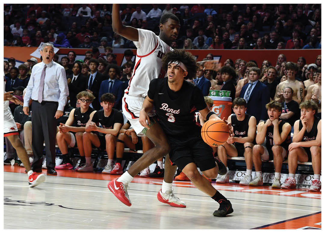 A basketball game is taking place with a group of men playing. One man is jumping in the air to grab the basketball while another player is running towards him. The crowd is watching the game intently. AI generated content