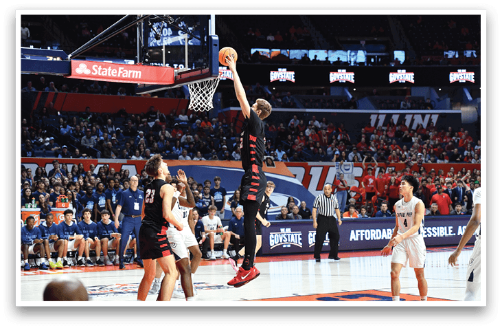 Basketball players are on the court, with one player jumping to block a shot. The crowd is watching the game intently. AI generated content