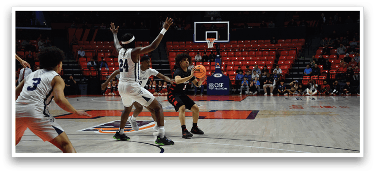 A basketball game is in progress with players on the court. A man is attempting to block a shot, while another player is holding the ball. There are several other players on the court, some of whom are wearing white uniforms. The scene is filled with excitement as the players compete against each other. AI generated content