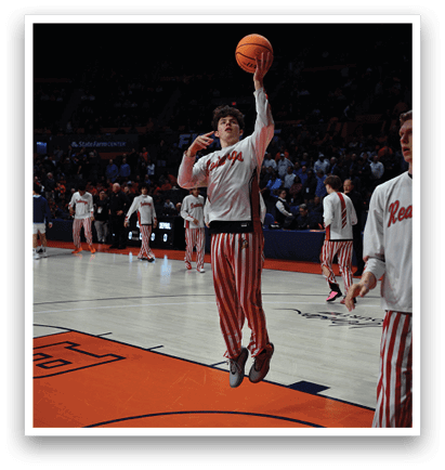 A basketball player in a white shirt and red and white striped pants is jumping to shoot a basketball. AI generated content