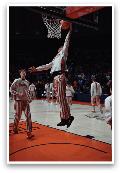 Two men wearing red and white striped pants are jumping in the air to dunk a basketball. AI generated content