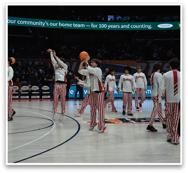 A group of young men wearing red and white striped pants are playing basketball. AI generated content