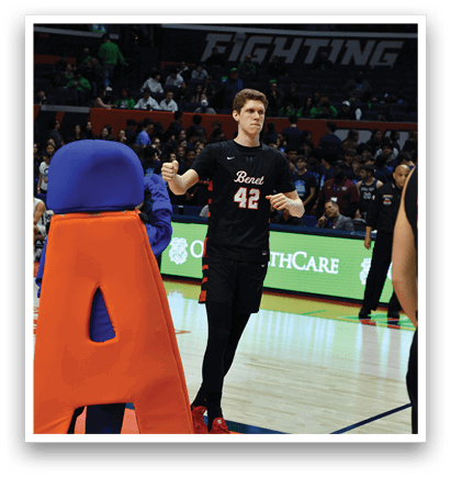 A man wearing a black shirt and number 42 stands on a basketball court. AI generated content