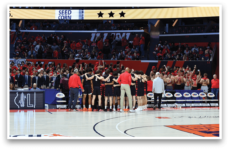 A group of people are standing on a basketball court, some of them wearing red shirts. They are holding hands and appear to be celebrating a victory. AI generated content