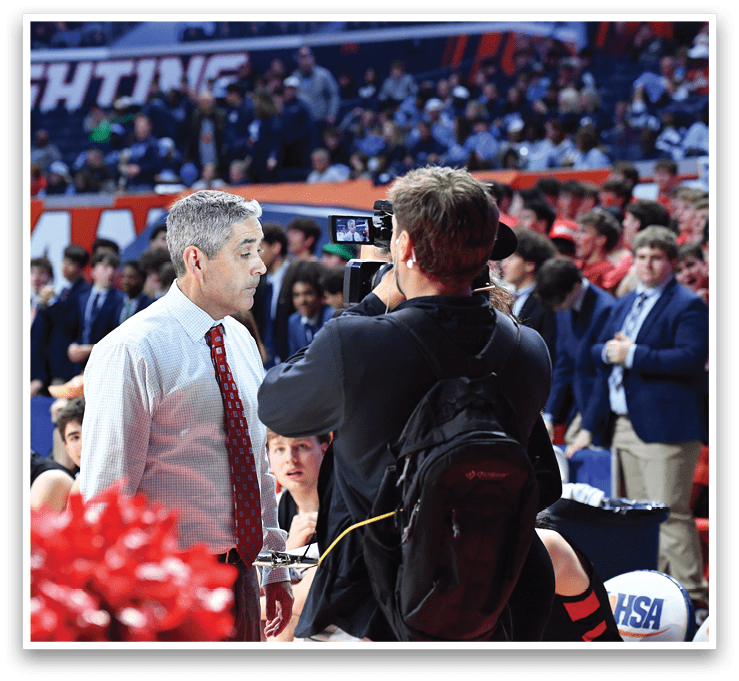 A man in a red tie is talking to a man holding a camera. AI generated content