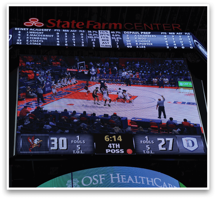 A basketball game is being played on a court with a large screen displaying the score. AI generated content