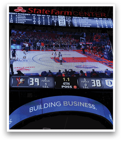 A basketball game is being displayed on a large screen with a crowd of people watching. AI generated content