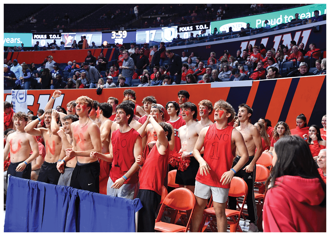 A group of young men wearing red shirts and red paint on their faces are standing in front of a crowd of people. AI generated content