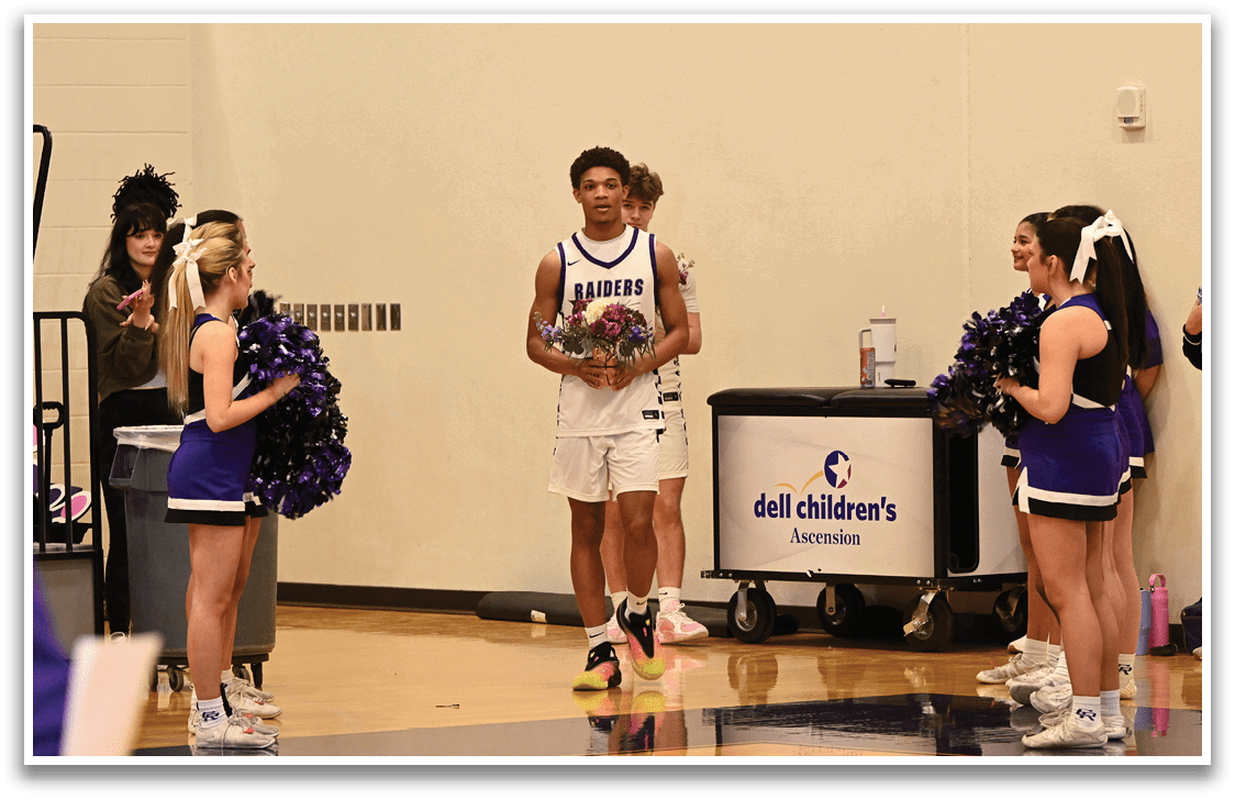 A group of cheerleaders stand on the court, one holding a bouquet of flowers. A man in a white jersey stands in front of them, holding a vase with flowers. Contenido generado con IA