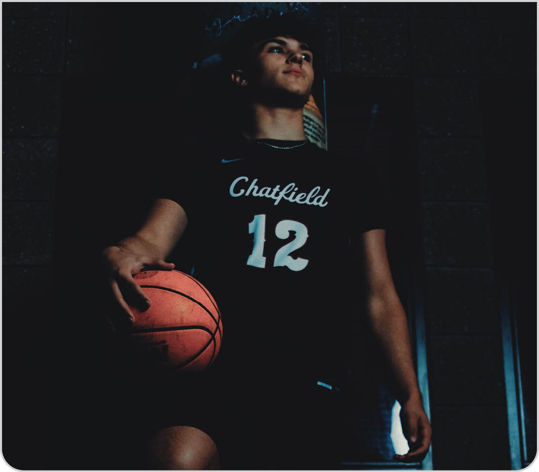 A man is holding a basketball in a dark room. AI generated content