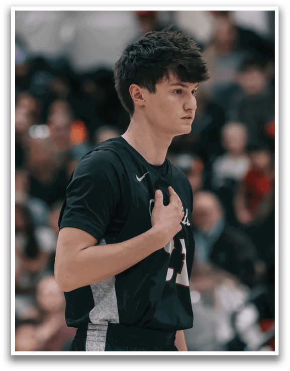 A young man wearing a black shirt and shorts stands on a basketball court, looking at the crowd. AI generated content