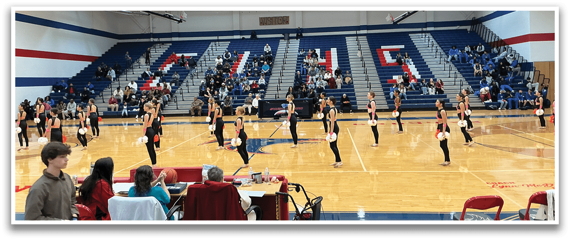 A group of women perform a dance routine on a basketball court. AI generated content