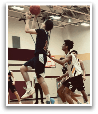 A basketball game is in progress with players on the court. One player is jumping to grab the ball while another player is trying to block him. The scene is set in a gymnasium with a referee present. AI generated content
