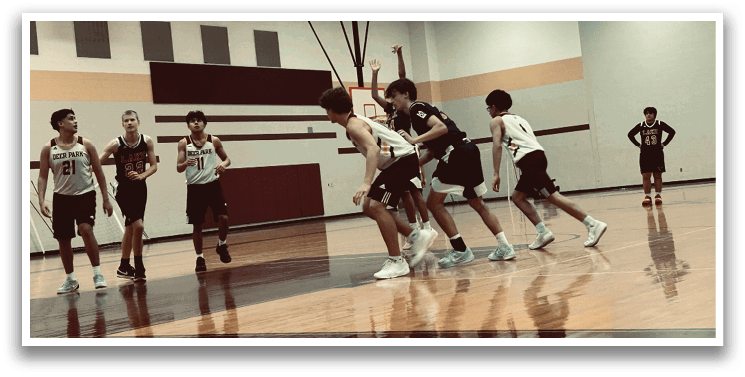A group of young men playing basketball in a gym. AI generated content