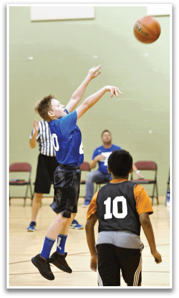 A boy in a blue shirt jumps to catch a basketball. AI generated content